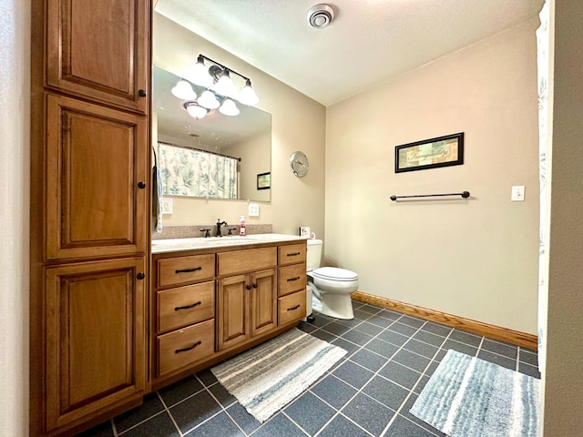 full bath featuring toilet, vanity, baseboards, and tile patterned floors