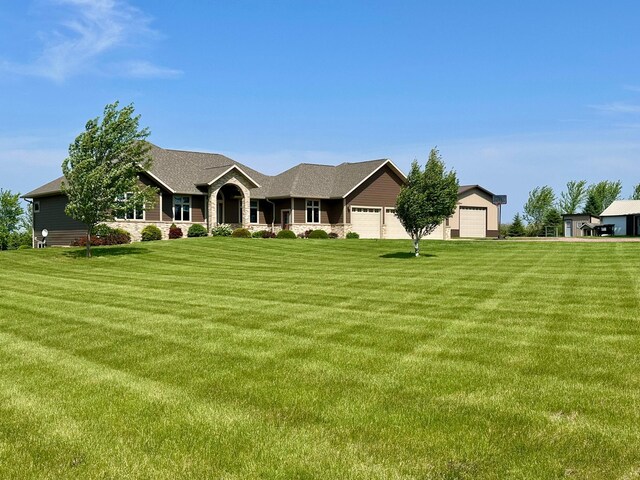 13943 Sundberg Ave, Graham Lakes Twp, MN 56131 - view of front facade with a front yard, stone siding, and a shingled roof