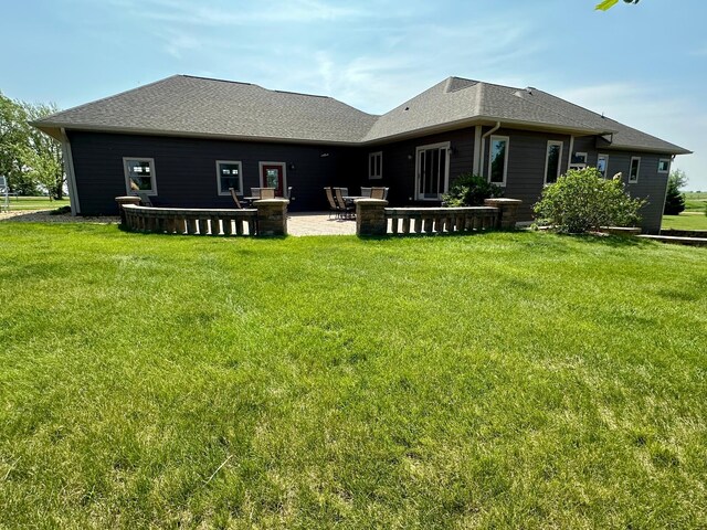 13943 Sundberg Ave, Graham Lakes Twp, MN 56131 - back of property with a lawn, a patio area, and a shingled roof