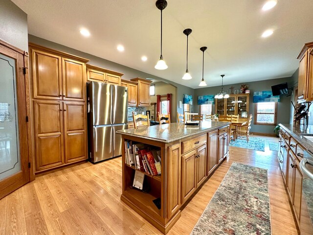 13943 Sundberg Ave, Graham Lakes Twp, MN 56131 - kitchen featuring freestanding refrigerator, open shelves, a center island, dark stone counters, and brown cabinetry