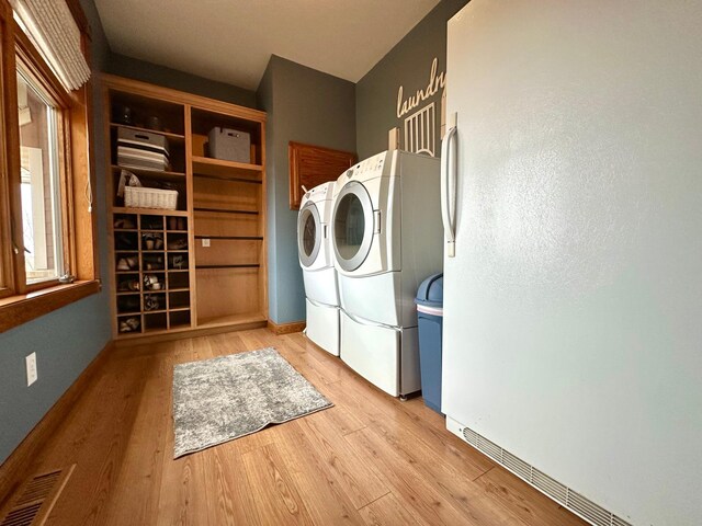 13943 Sundberg Ave, Graham Lakes Twp, MN 56131 - laundry room featuring washing machine and clothes dryer, wood finished floors, and baseboards