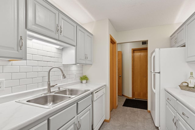 kitchen with white appliances, light tile patterned floors, visible vents, light countertops, and a sink