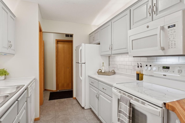 kitchen with white appliances, light tile patterned floors, visible vents, decorative backsplash, and light countertops