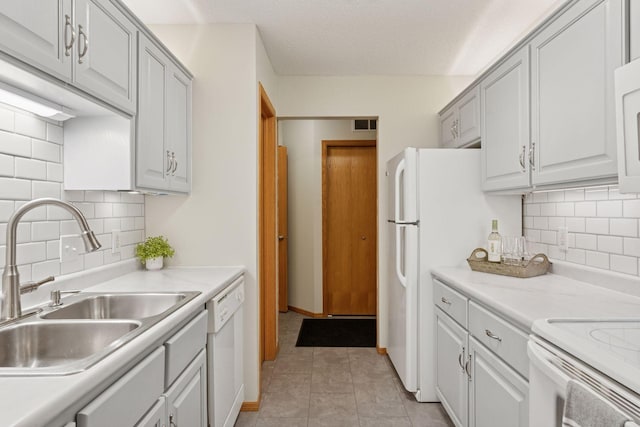 kitchen featuring light countertops, visible vents, light tile patterned flooring, a sink, and dishwasher