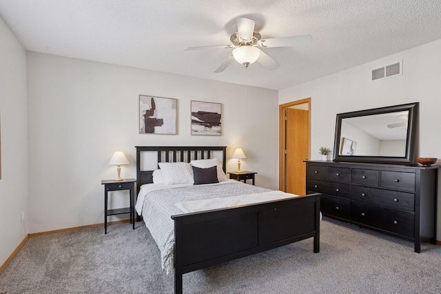 bedroom with a textured ceiling, carpet floors, a ceiling fan, visible vents, and baseboards