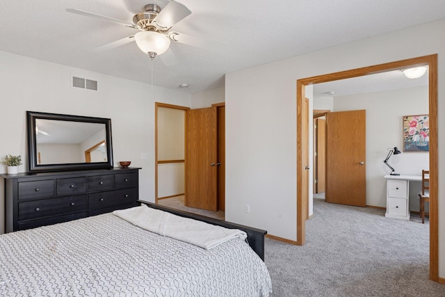 bedroom featuring baseboards, visible vents, a ceiling fan, a textured ceiling, and carpet floors