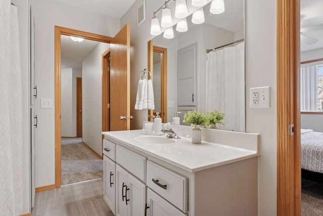 ensuite bathroom featuring visible vents, connected bathroom, and vanity