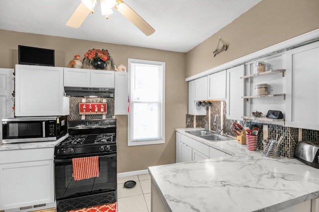 kitchen with black gas range oven, white cabinetry, sink, decorative backsplash, and light tile patterned floors