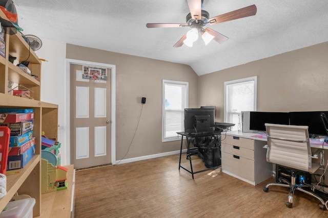 office space featuring ceiling fan, vaulted ceiling, and light wood-type flooring