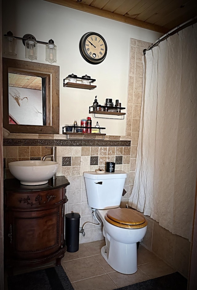 bathroom featuring tile patterned flooring, toilet, a shower with curtain, tile walls, and vanity