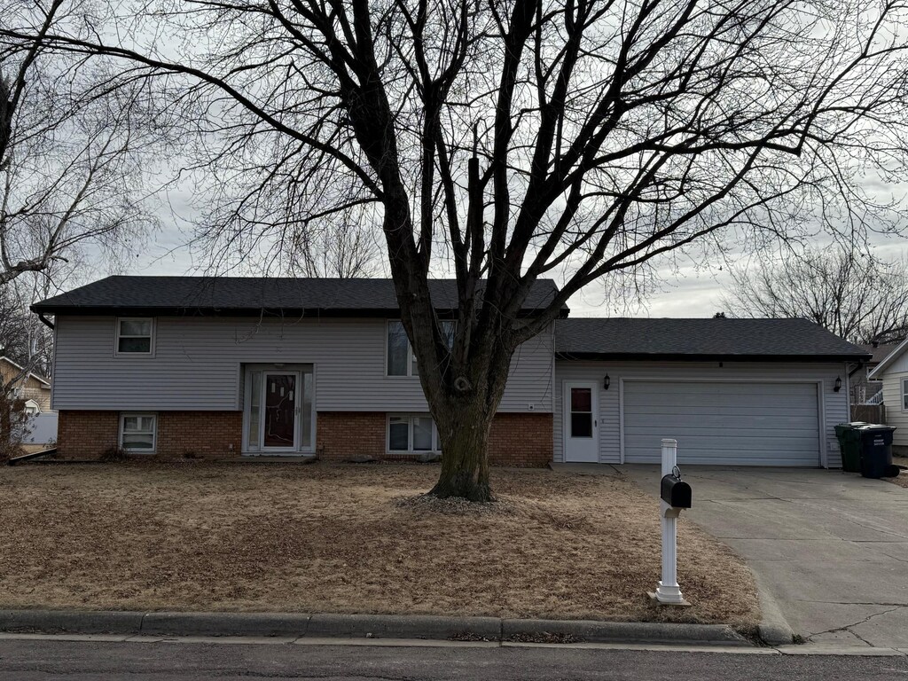 raised ranch with concrete driveway and an attached garage