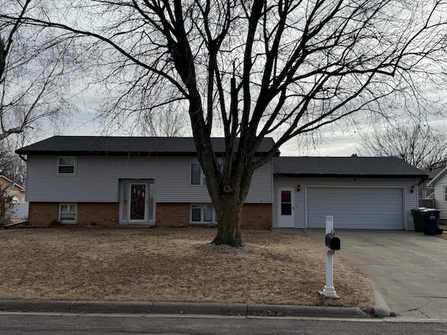 raised ranch with concrete driveway and an attached garage