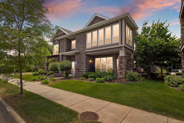 tudor-style house with brick siding and a yard