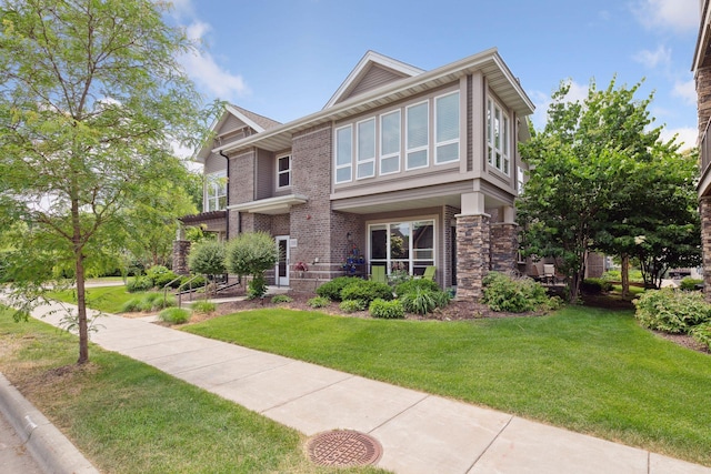 view of front facade with brick siding and a front lawn