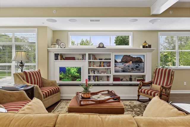 interior space featuring visible vents, wood finished floors, a wealth of natural light, and baseboards