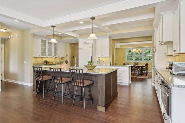 kitchen with a center island, dark wood-style flooring, and white cabinets