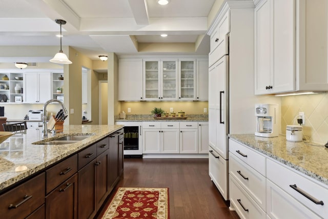 kitchen with glass insert cabinets, white cabinetry, a sink, and dark wood-type flooring