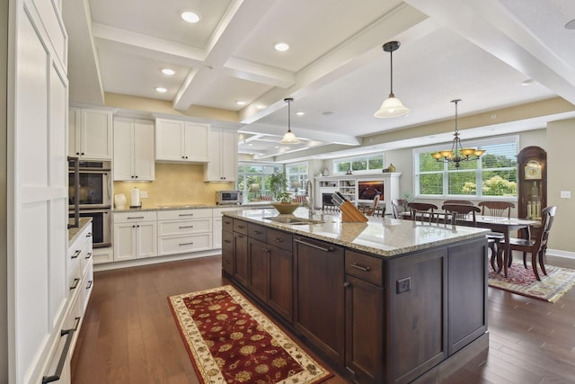 kitchen with beamed ceiling, dark wood finished floors, dark brown cabinetry, and white cabinets