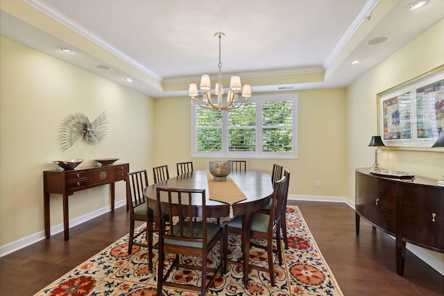 dining space featuring dark wood-type flooring, a raised ceiling, ornamental molding, and baseboards