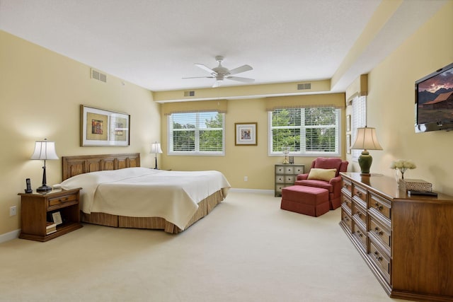 bedroom with baseboards, visible vents, and light colored carpet