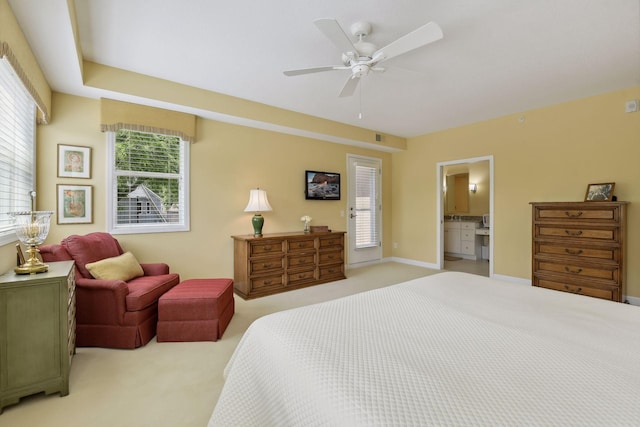 bedroom with light carpet, connected bathroom, a ceiling fan, and baseboards