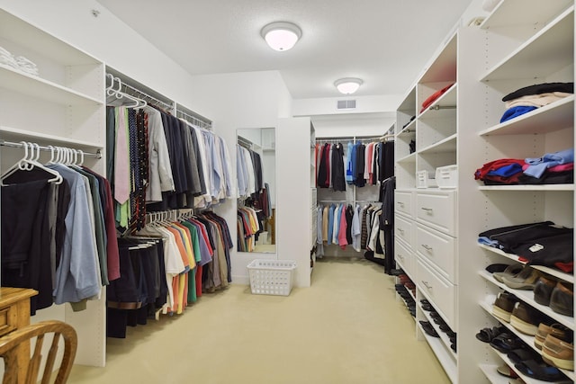 walk in closet featuring light carpet and visible vents