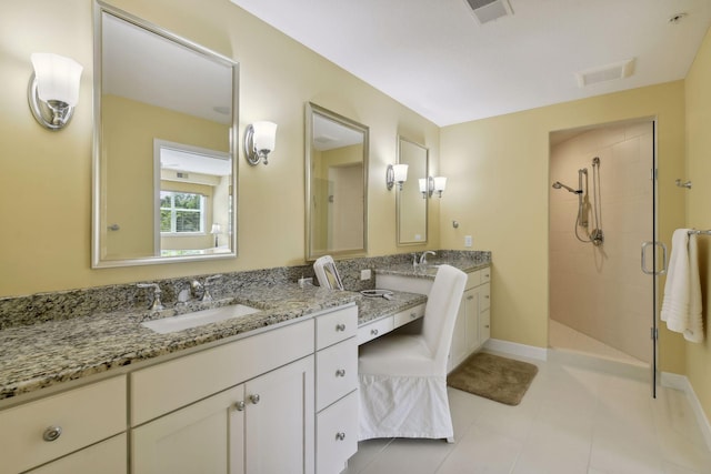 full bath featuring tile patterned flooring, baseboards, a shower stall, and vanity