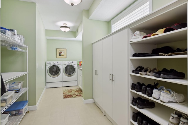 clothes washing area featuring baseboards and washer and dryer