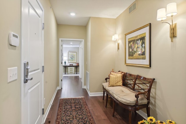 hallway featuring dark wood-style flooring, visible vents, and baseboards