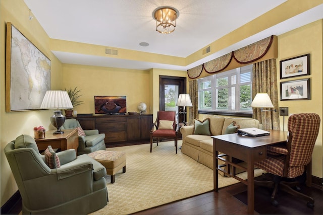 living area featuring visible vents and hardwood / wood-style flooring