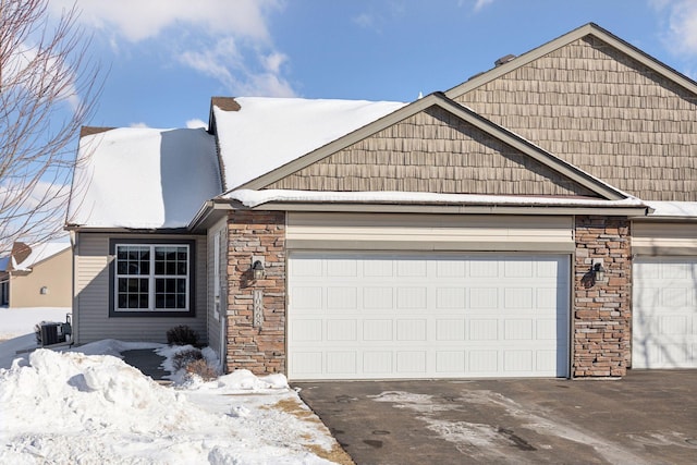 view of front of home featuring stone siding, driveway, and an attached garage