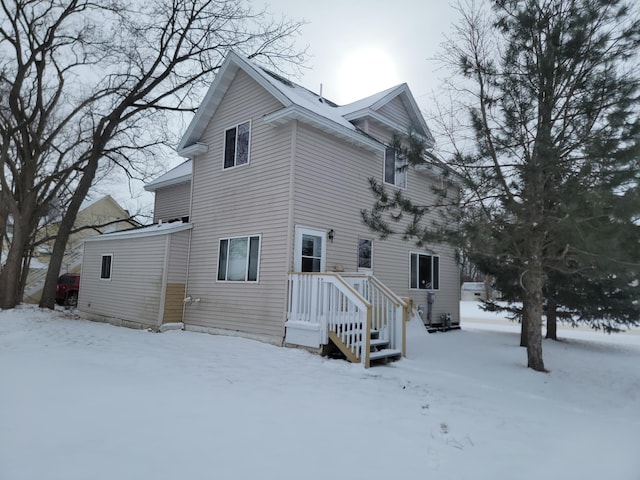 view of snow covered back of property