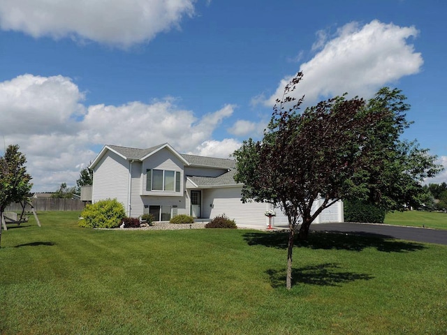 view of front of house with a garage, a front yard, driveway, and fence