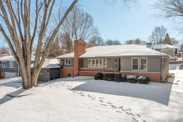 ranch-style home featuring a chimney, an outbuilding, a detached garage, and brick siding