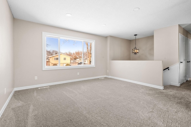 empty room with carpet floors and a textured ceiling