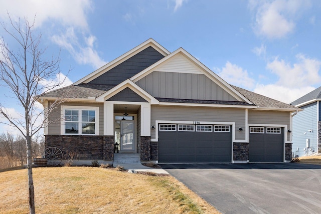 craftsman inspired home with a garage, stone siding, roof with shingles, and driveway