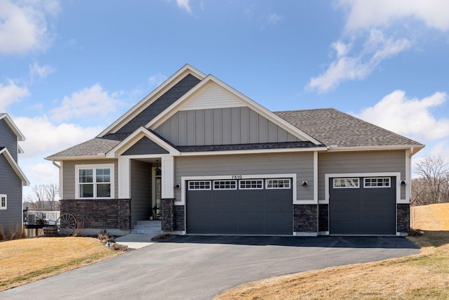 craftsman inspired home featuring stone siding, roof with shingles, driveway, and an attached garage