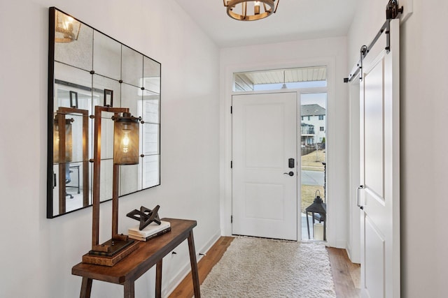 foyer featuring light wood-type flooring and a barn door