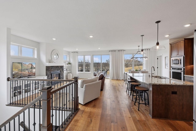 living area featuring a fireplace, light wood-style flooring, and recessed lighting