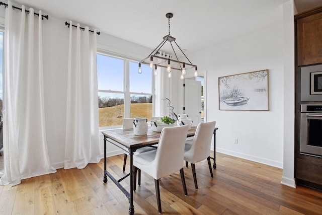 dining room featuring light wood-style flooring and baseboards