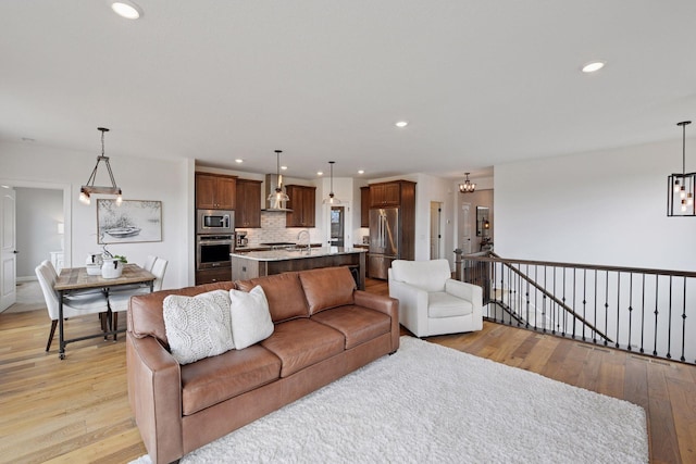 living room featuring light wood-type flooring, an inviting chandelier, and recessed lighting