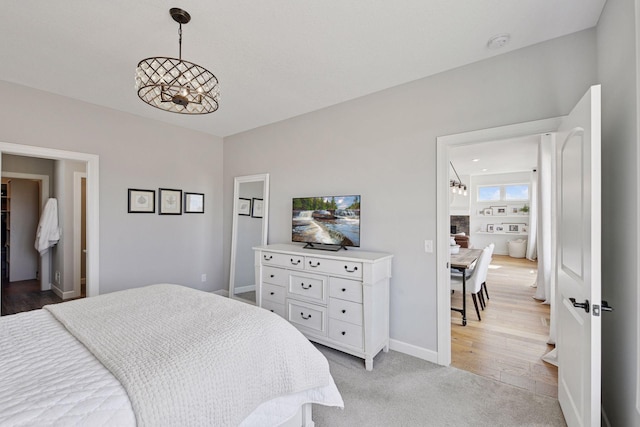 bedroom with light colored carpet and baseboards