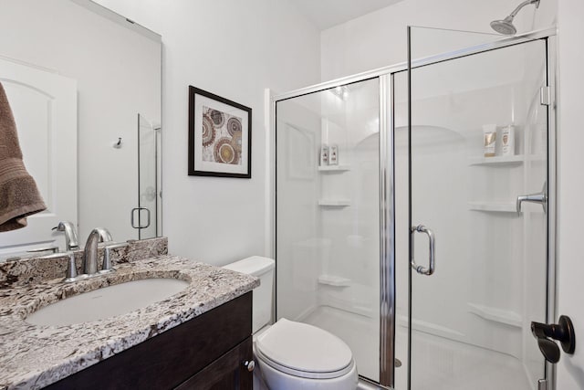 bathroom featuring a stall shower, vanity, and toilet