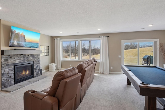 carpeted living area with pool table, a stone fireplace, baseboards, and a textured ceiling