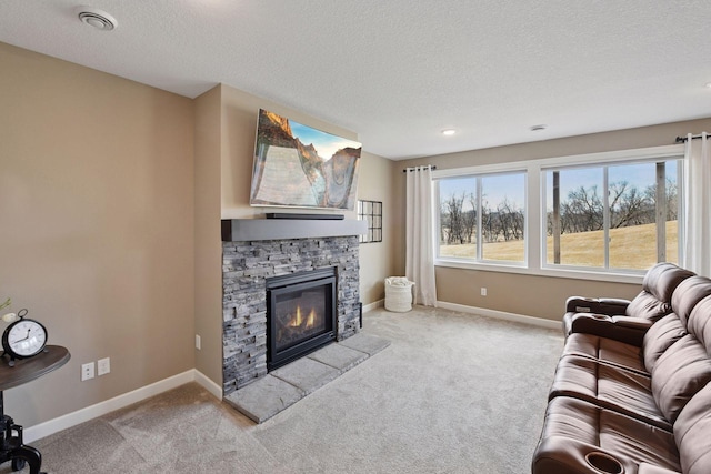 living area featuring carpet floors, visible vents, a stone fireplace, and baseboards