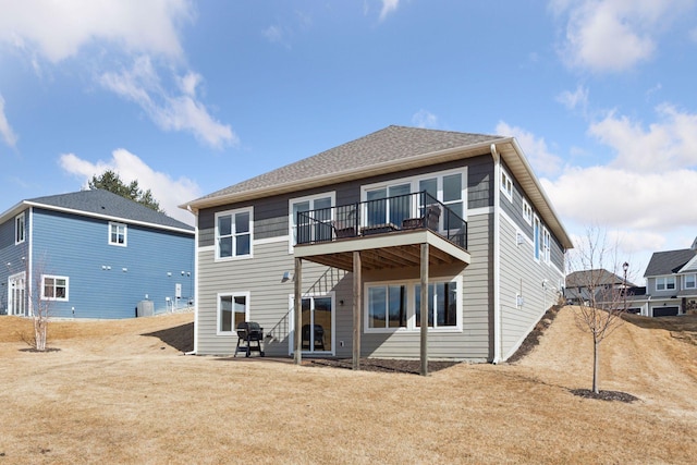 back of property featuring roof with shingles