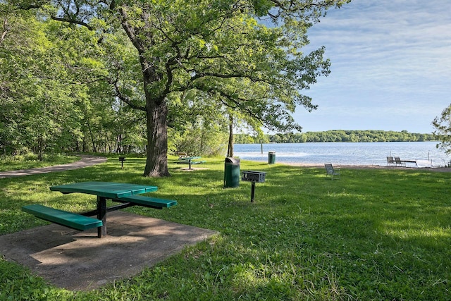 surrounding community featuring a water view and a yard