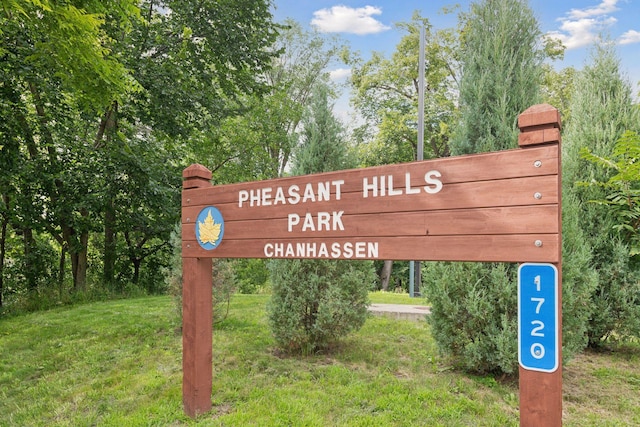 community / neighborhood sign featuring a lawn