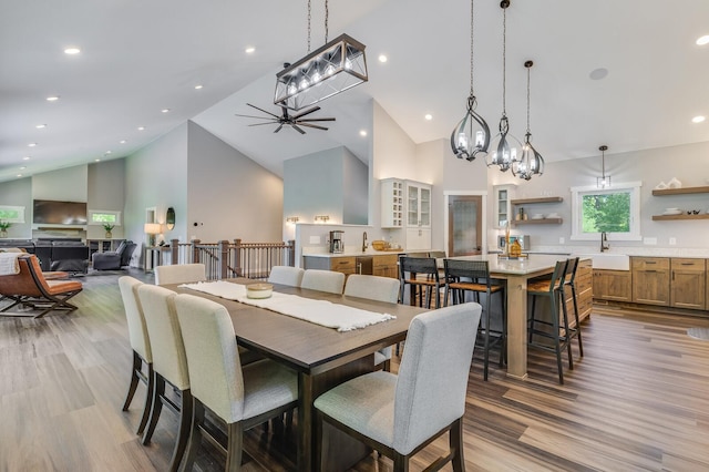 dining area featuring light wood finished floors, high vaulted ceiling, a ceiling fan, and recessed lighting