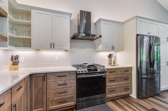 kitchen with dark wood-style floors, open shelves, stainless steel appliances, wall chimney range hood, and light stone countertops